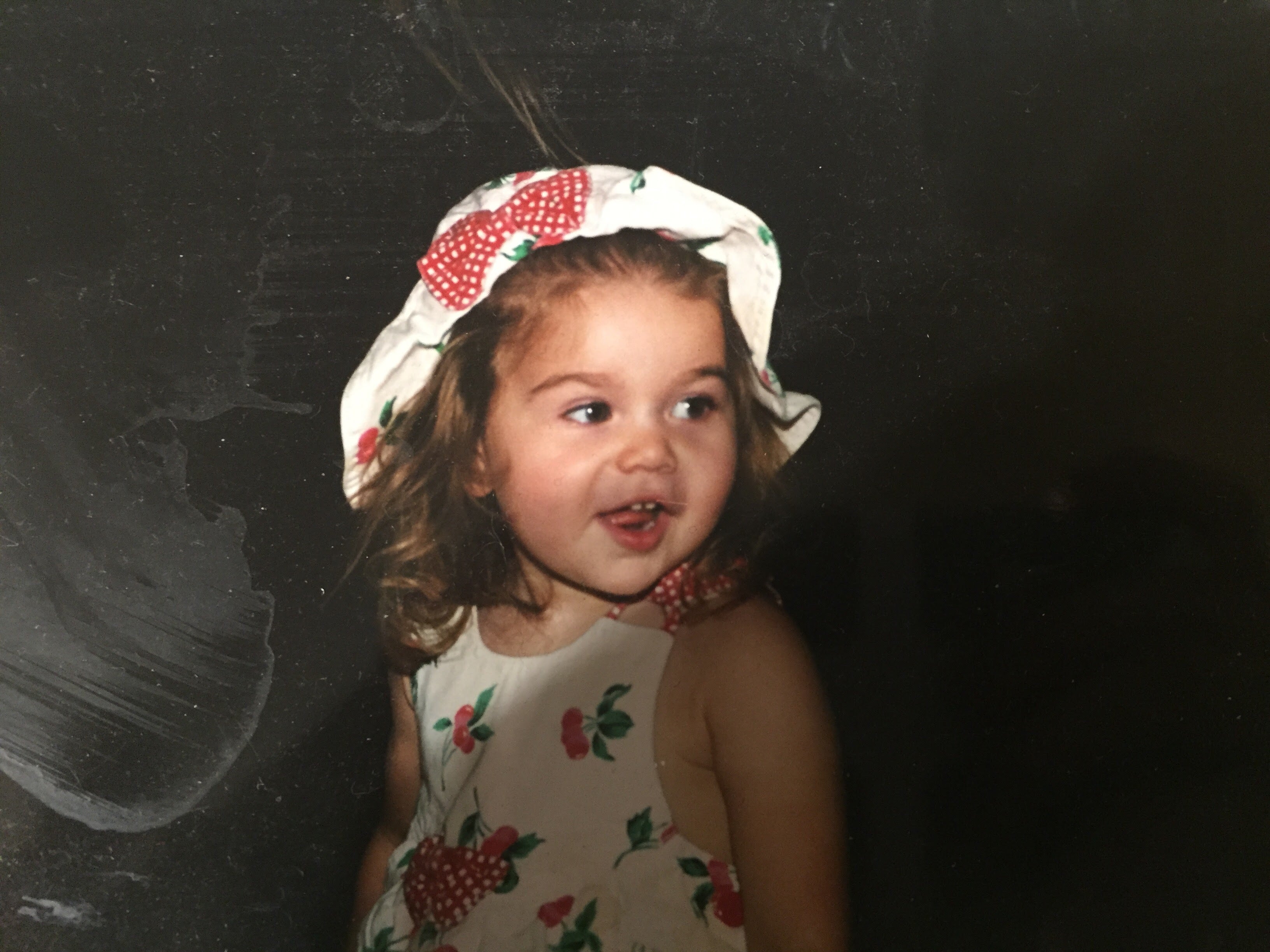 Young girl in a vintage strawberry print dress and hat - founder of Strawberry Afternoon as a child